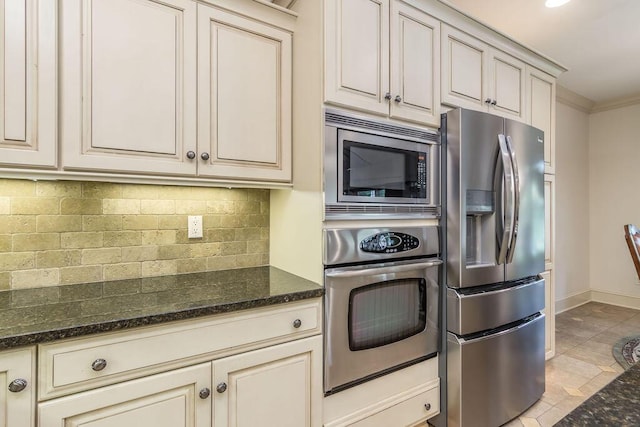 903 Silver Bluff Cir, Branson West, MO 65737 - kitchen featuring stainless steel appliances, cream cabinets, tasteful backsplash, baseboards, and dark stone countertops