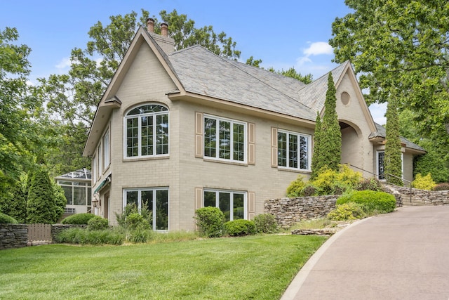 5575 S Castlebay Dr, Springfield, MO 65809 - view of home's exterior featuring a chimney, a lawn, and roof with shingles
