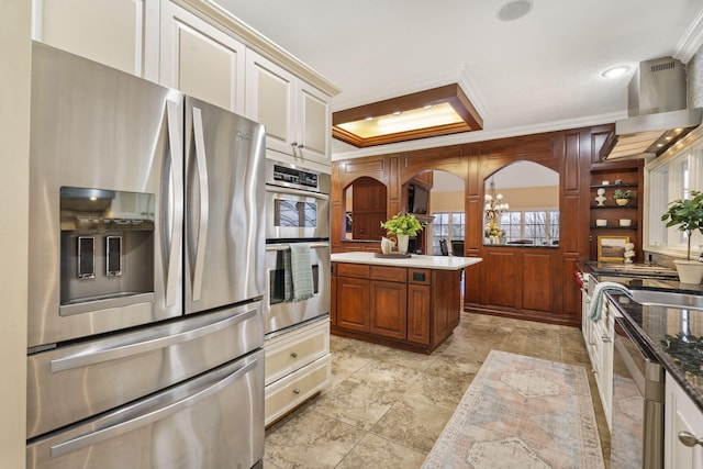 5575 S Castlebay Dr, Springfield, MO 65809 - kitchen featuring stainless steel appliances, ornamental molding, wall chimney range hood, and a tray ceiling