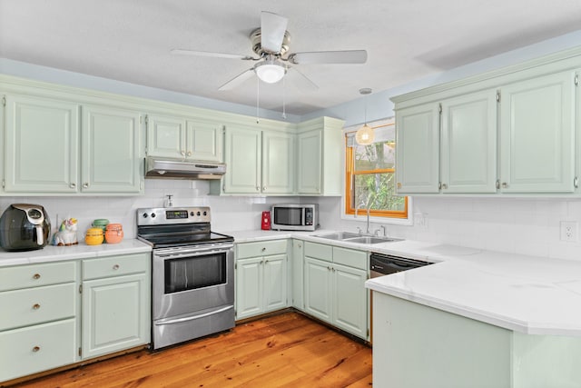 3645 S Ridgecrest Ave, Springfield, MO 65807 - kitchen featuring appliances with stainless steel finishes, under cabinet range hood, a peninsula, a sink, and light wood-style floors