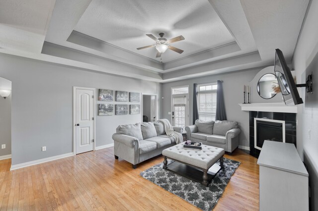 3192 W Melbourne St, Springfield, MO 65810 - living area with a ceiling fan, a tray ceiling, light wood-style floors, and baseboards