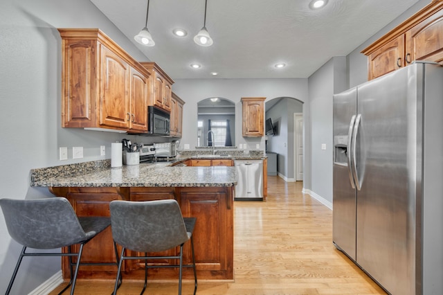 3192 W Melbourne St, Springfield, MO 65810 - kitchen with appliances with stainless steel finishes, arched walkways, a peninsula, a sink, and a kitchen breakfast bar