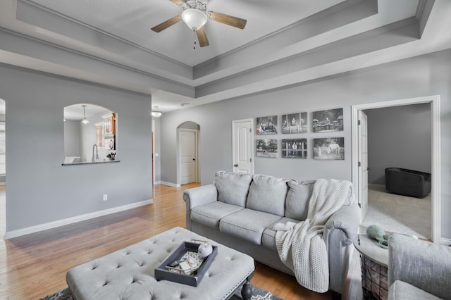 3192 W Melbourne St, Springfield, MO 65810 - living room with arched walkways, a raised ceiling, a ceiling fan, crown molding, and baseboards