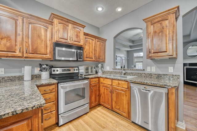 3192 W Melbourne St, Springfield, MO 65810 - kitchen with stainless steel appliances, a sink, light wood-type flooring, arched walkways, and recessed lighting