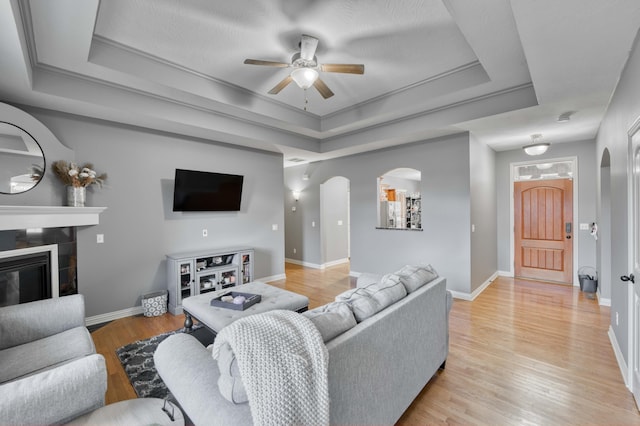 3192 W Melbourne St, Springfield, MO 65810 - living area with a raised ceiling, arched walkways, ceiling fan, and baseboards