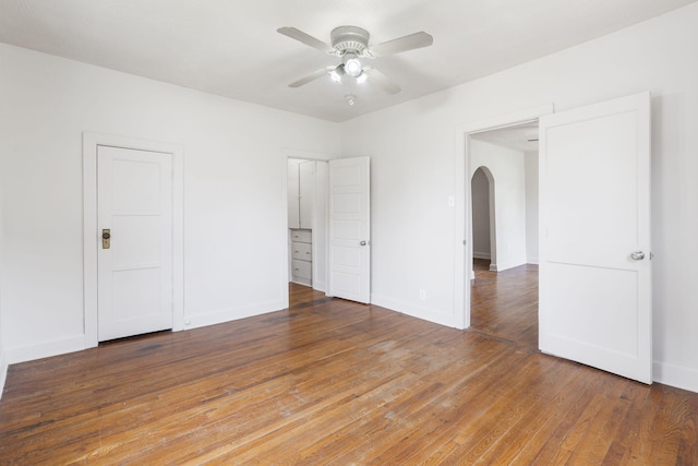 2500 W Mount Vernon St, Springfield, MO 65802 - unfurnished bedroom with arched walkways, wood finished floors, baseboards, and ceiling fan