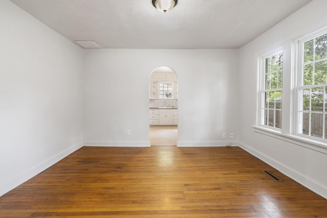 2500 W Mount Vernon St, Springfield, MO 65802 - unfurnished room with arched walkways, plenty of natural light, wood finished floors, and a sink