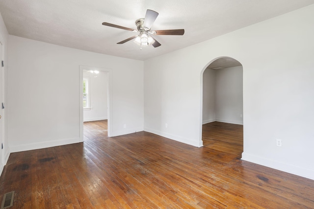 2500 W Mount Vernon St, Springfield, MO 65802 - spare room with arched walkways, a ceiling fan, wood-type flooring, and baseboards