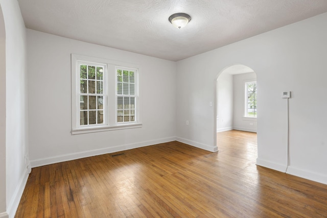 2500 W Mount Vernon St, Springfield, MO 65802 - spare room with arched walkways, plenty of natural light, hardwood / wood-style flooring, and baseboards