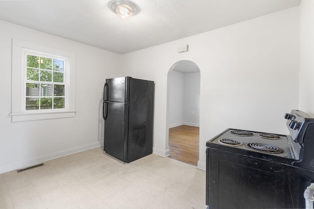 2500 W Mount Vernon St, Springfield, MO 65802 - kitchen with black appliances, arched walkways, light floors, and baseboards
