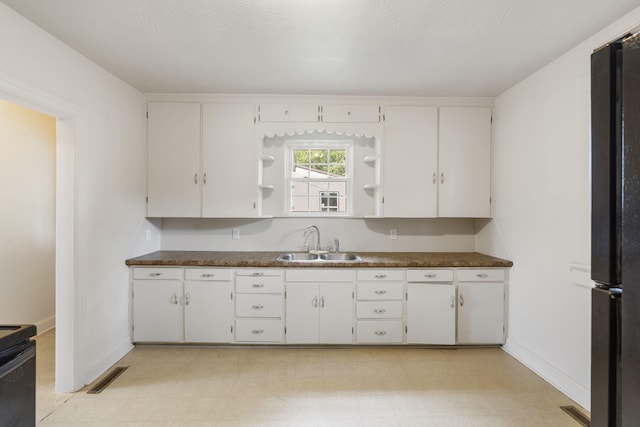 2500 W Mount Vernon St, Springfield, MO 65802 - kitchen featuring a sink, open shelves, dark countertops, and white cabinetry