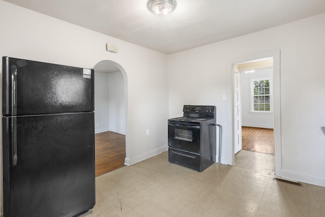 2500 W Mount Vernon St, Springfield, MO 65802 - kitchen with black appliances, arched walkways, baseboards, and light flooring