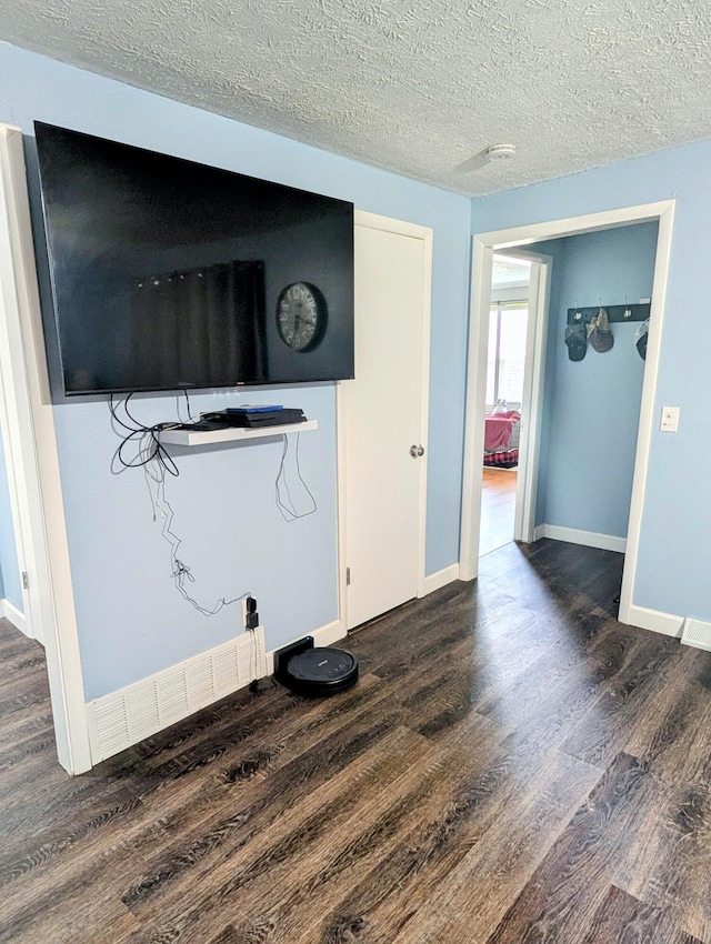 204 E College St, Walnut Grove, MO 65770 - living area featuring dark wood-type flooring, baseboards, and a textured ceiling