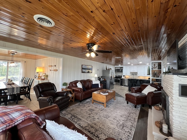 21937 Lake Rd Unit M12, Cassville, MO 65625 - living area featuring wooden ceiling, light wood-type flooring, a stone fireplace, and a ceiling fan
