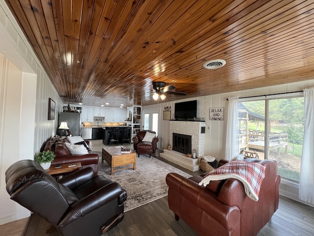 21937 Lake Rd Unit M12, Cassville, MO 65625 - living room with a ceiling fan, wood ceiling, a brick fireplace, plenty of natural light, and dark wood-type flooring
