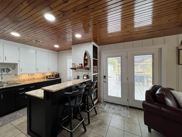 21937 Lake Rd Unit M12, Cassville, MO 65625 - kitchen featuring wooden ceiling, light tile patterned flooring, white cabinetry, a peninsula, and dark cabinets