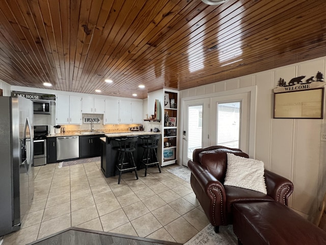21937 Lake Rd Unit M12, Cassville, MO 65625 - kitchen with appliances with stainless steel finishes, light tile patterned floors, light countertops, a sink, and a breakfast bar