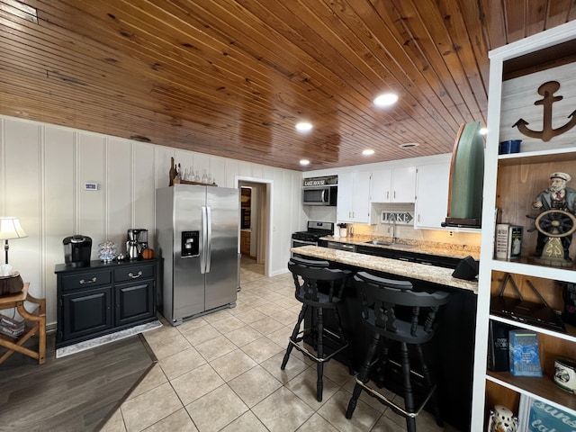 21937 Lake Rd Unit M12, Cassville, MO 65625 - kitchen featuring appliances with stainless steel finishes, a sink, wooden ceiling, a peninsula, and light tile patterned floors