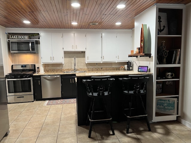 21937 Lake Rd Unit M12, Cassville, MO 65625 - kitchen with appliances with stainless steel finishes, a sink, light tile patterned flooring, white cabinets, and wooden ceiling