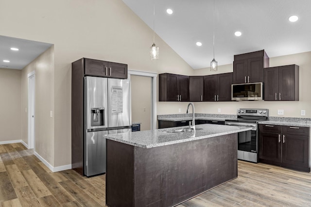 1186 Emory Creek Blvd, Branson, MO 65616 - kitchen featuring appliances with stainless steel finishes, a sink, dark brown cabinetry, light stone counters, and pendant lighting