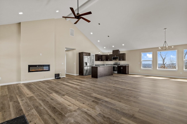 1186 Emory Creek Blvd, Branson, MO 65616 - unfurnished living room featuring high vaulted ceiling, a ceiling fan, wood finished floors, beam ceiling, and a glass covered fireplace