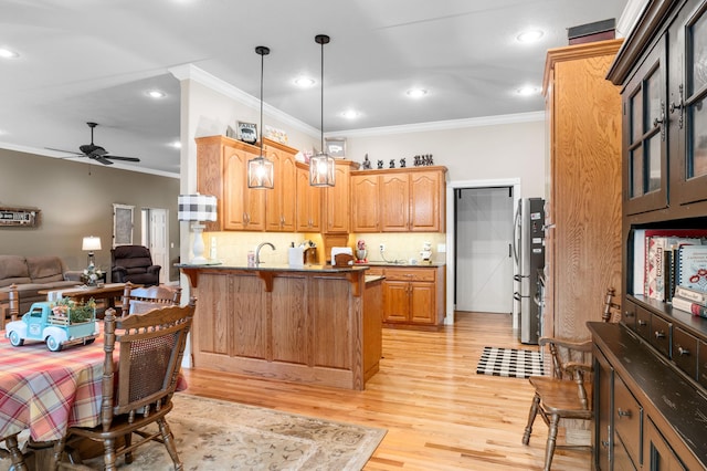 4266 S 94th Rd, Bolivar, MO 65613 - kitchen featuring ornamental molding, a peninsula, a ceiling fan, a breakfast bar, and decorative backsplash