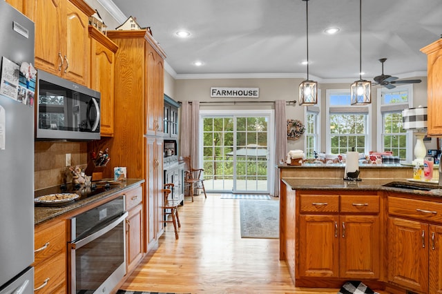 4266 S 94th Rd, Bolivar, MO 65613 - kitchen featuring stainless steel appliances, ornamental molding, light wood finished floors, ceiling fan, and brown cabinetry