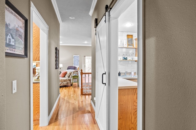 4266 S 94th Rd, Bolivar, MO 65613 - hallway featuring a textured wall, a barn door, light wood-type flooring, ornamental molding, and recessed lighting