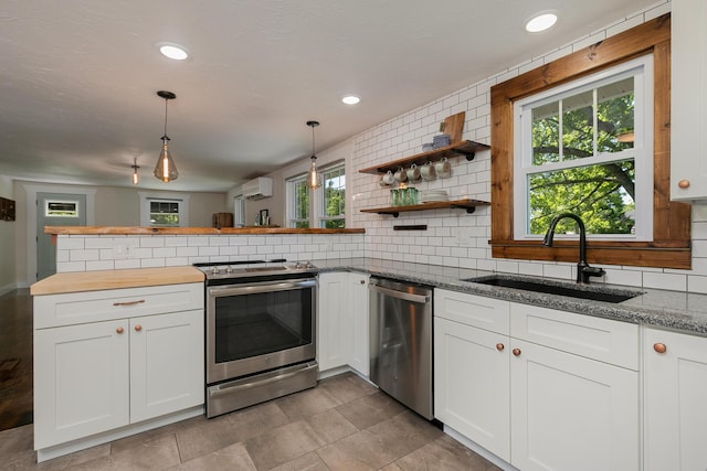 439 Union Chapel Rd, Fordland, MO 65652 - kitchen featuring appliances with stainless steel finishes, a sink, an AC wall unit, backsplash, and white cabinets