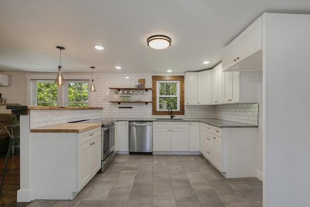 439 Union Chapel Rd, Fordland, MO 65652 - kitchen with appliances with stainless steel finishes, a sink, a peninsula, decorative backsplash, and white cabinets