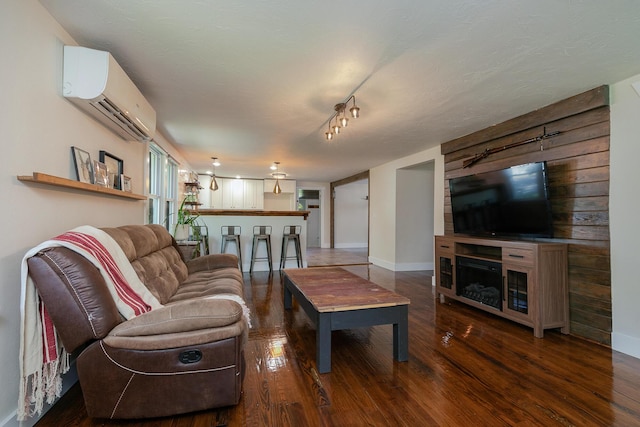 439 Union Chapel Rd, Fordland, MO 65652 - living area featuring a wall unit AC, wood finished floors, and baseboards