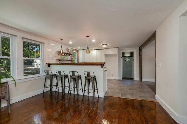 439 Union Chapel Rd, Fordland, MO 65652 - kitchen with white cabinetry, a peninsula, a breakfast bar, pendant lighting, and dark wood-type flooring