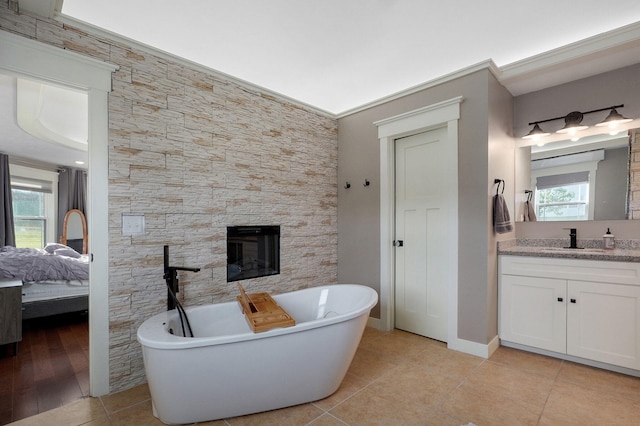 5116 S 165th Rd, Bolivar, MO 65613 - full bathroom with a freestanding tub, vanity, ensuite bath, a glass covered fireplace, and tile patterned floors