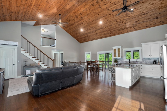 5116 S 165th Rd, Bolivar, MO 65613 - living room featuring a ceiling fan, high vaulted ceiling, dark wood-style floors, stairway, and an AC wall unit