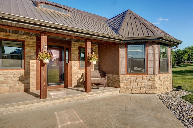 5116 S 165th Rd, Bolivar, MO 65613 - doorway to property with stone siding, a standing seam roof, a porch, and metal roof