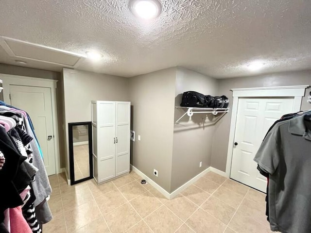 5116 S 165th Rd, Bolivar, MO 65613 - laundry area with attic access, a textured ceiling, light tile patterned flooring, and baseboards