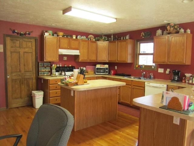 32880 Normal Dr, Eldridge, MO 65463 - kitchen featuring under cabinet range hood, dishwasher, stainless steel microwave, light countertops, and a sink
