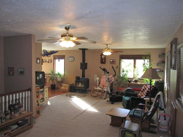 32880 Normal Dr, Eldridge, MO 65463 - carpeted living room with a wood stove, a textured ceiling, and ceiling fan
