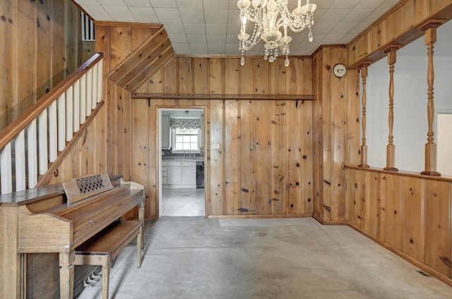 17381 Imperial Rd, Carthage, MO 64836 - dining space with wood walls, a chandelier, stairway, and concrete flooring