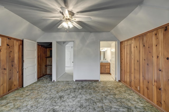 17381 Imperial Rd, Carthage, MO 64836 - unfurnished bedroom featuring light colored carpet, lofted ceiling, wood walls, ceiling fan, and connected bathroom