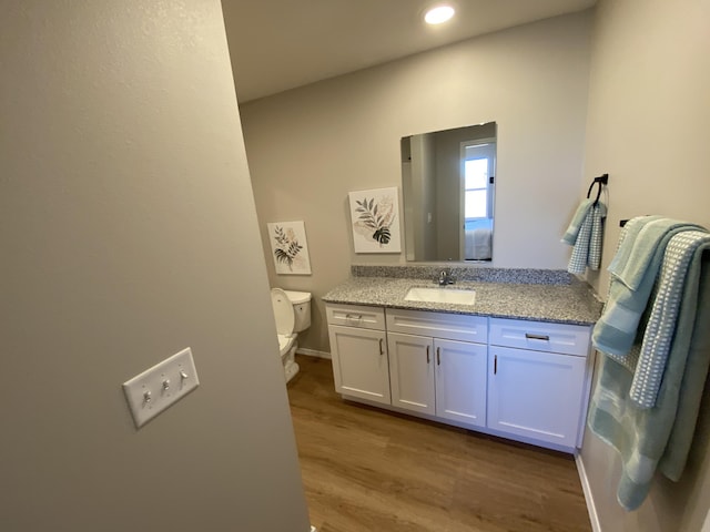 1221 Charlene Dr, Bolivar, MO 65613 - bathroom featuring toilet, vanity, wood finished floors, recessed lighting, and baseboards