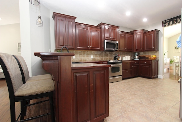 2362 Hazelwood Rd, Seymour, MO 65746 - kitchen with stainless steel appliances, tasteful backsplash, decorative light fixtures, a peninsula, and recessed lighting