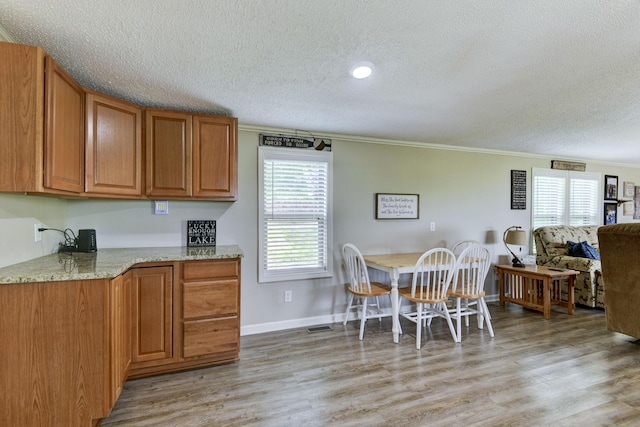 269 Moore Ln, Blue Eye, MO 65611 - dining area featuring a textured ceiling, crown molding, light wood-style flooring, and baseboards