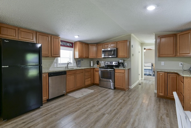 269 Moore Ln, Blue Eye, MO 65611 - kitchen featuring appliances with stainless steel finishes, light wood-style floors, a sink, ornamental molding, and light stone counters