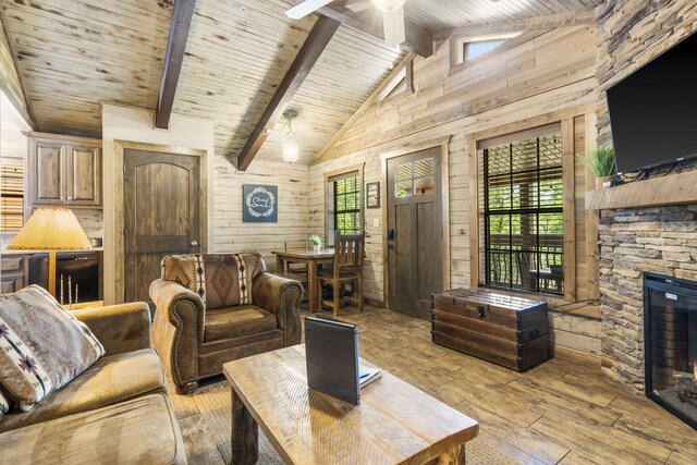 26 Cave Ln Unit 10, Indian Point, MO 65616 - living area with a stone fireplace, light wood-type flooring, wooden walls, wooden ceiling with exposed beams, and ceiling fan