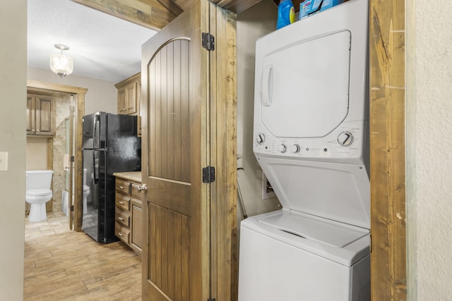 26 Cave Ln Unit 10, Indian Point, MO 65616 - washroom featuring stacked washing machine and dryer and light wood-style floors