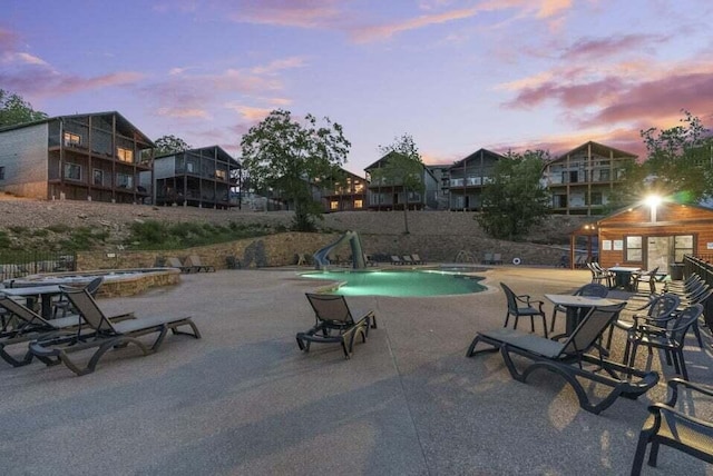 26 Cave Ln Unit 10, Indian Point, MO 65616 - pool at dusk with a community pool, a patio, and a water slide