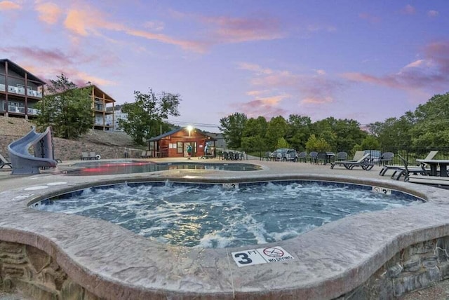 26 Cave Ln Unit 10, Indian Point, MO 65616 - community pool featuring a hot tub, a water slide, and a patio area
