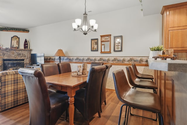 24 Village Trl Unit 13-2, Branson, MO 65616 - dining area with a chandelier, wood finished floors, a fireplace, and a wainscoted wall