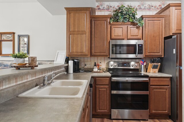 24 Village Trl Unit 13-2, Branson, MO 65616 - kitchen featuring stainless steel appliances, a sink, light countertops, and brown cabinets